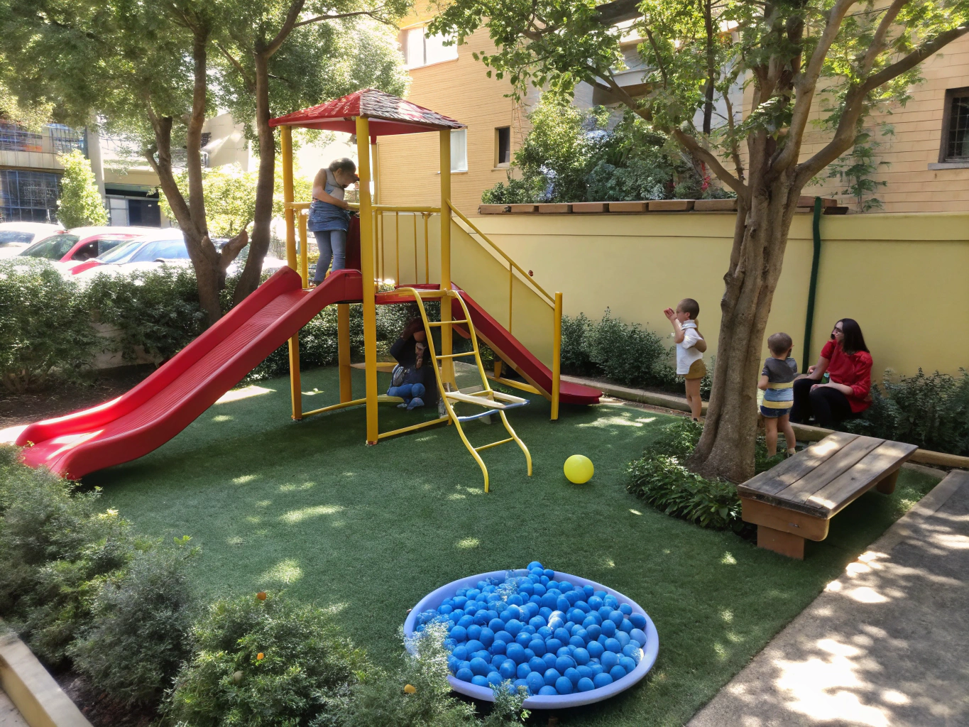 Cushioned synthetic grass playground surfacing around colorful slides and play equipment