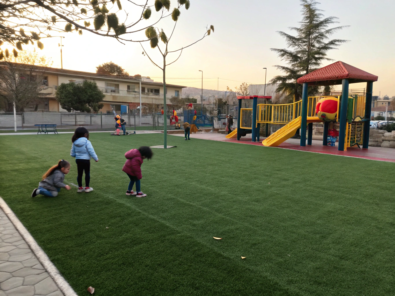 School playground play equipment set upon seamless artificial grass surface